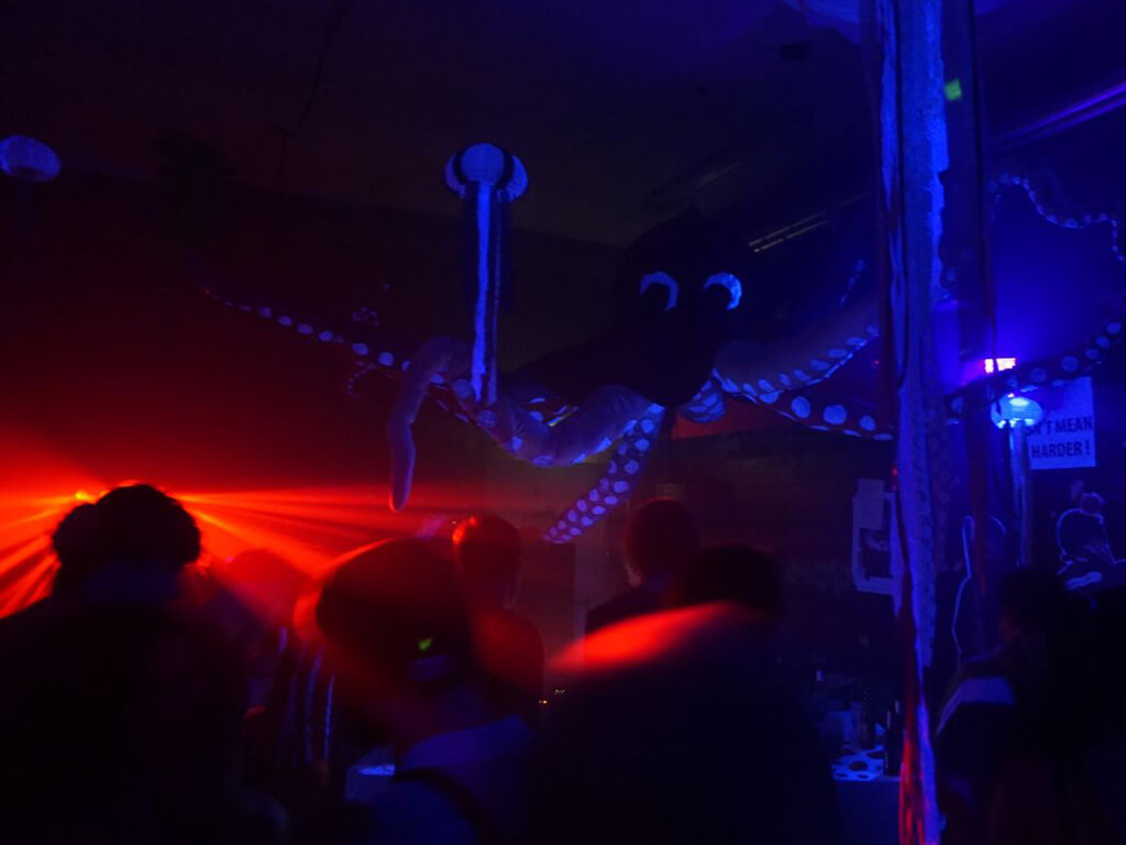 Krake über dem DJ Pult mit rotem Laser